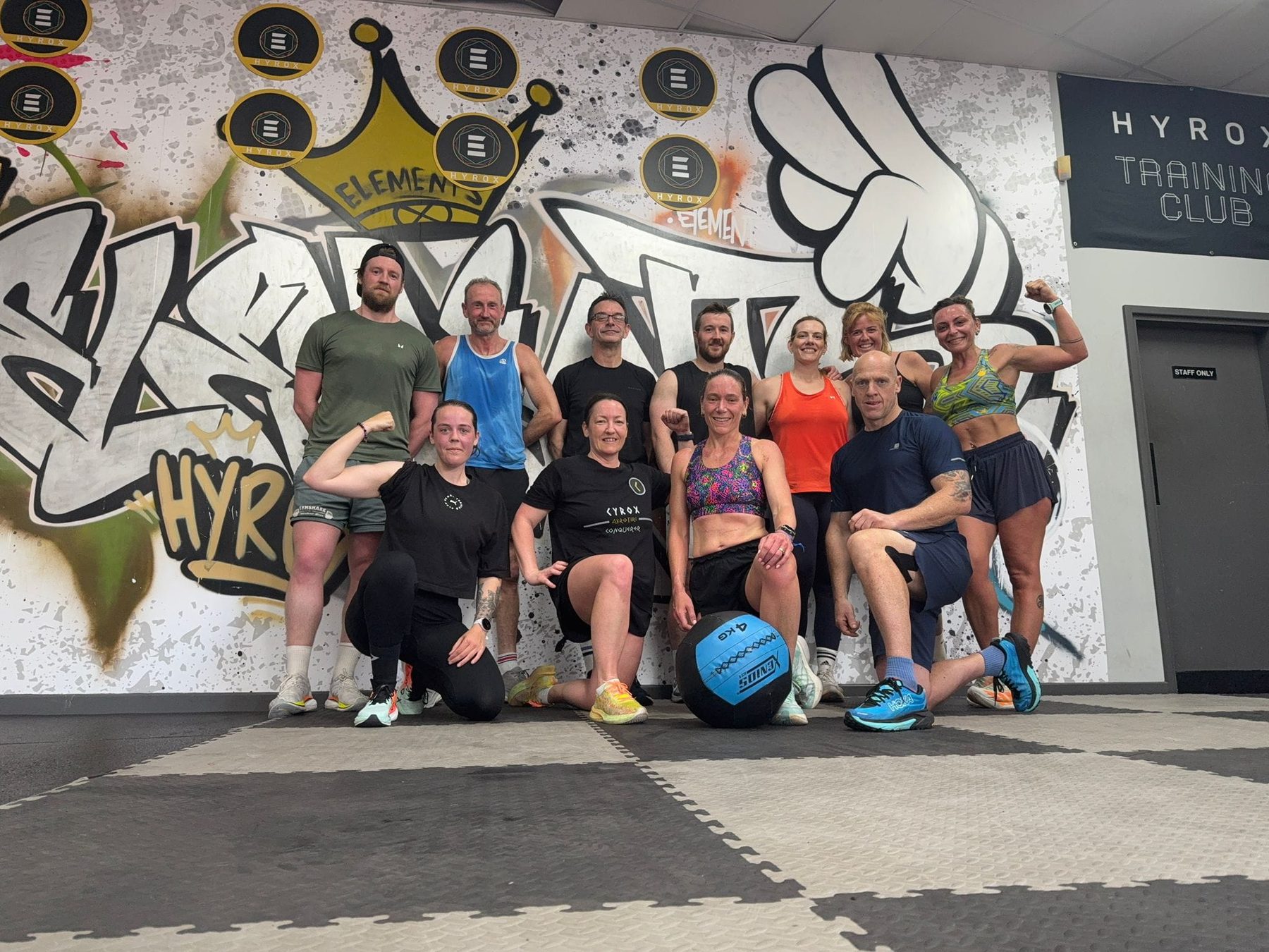 SlavFit training group in the gym in front of the SLAV Hyrox mural